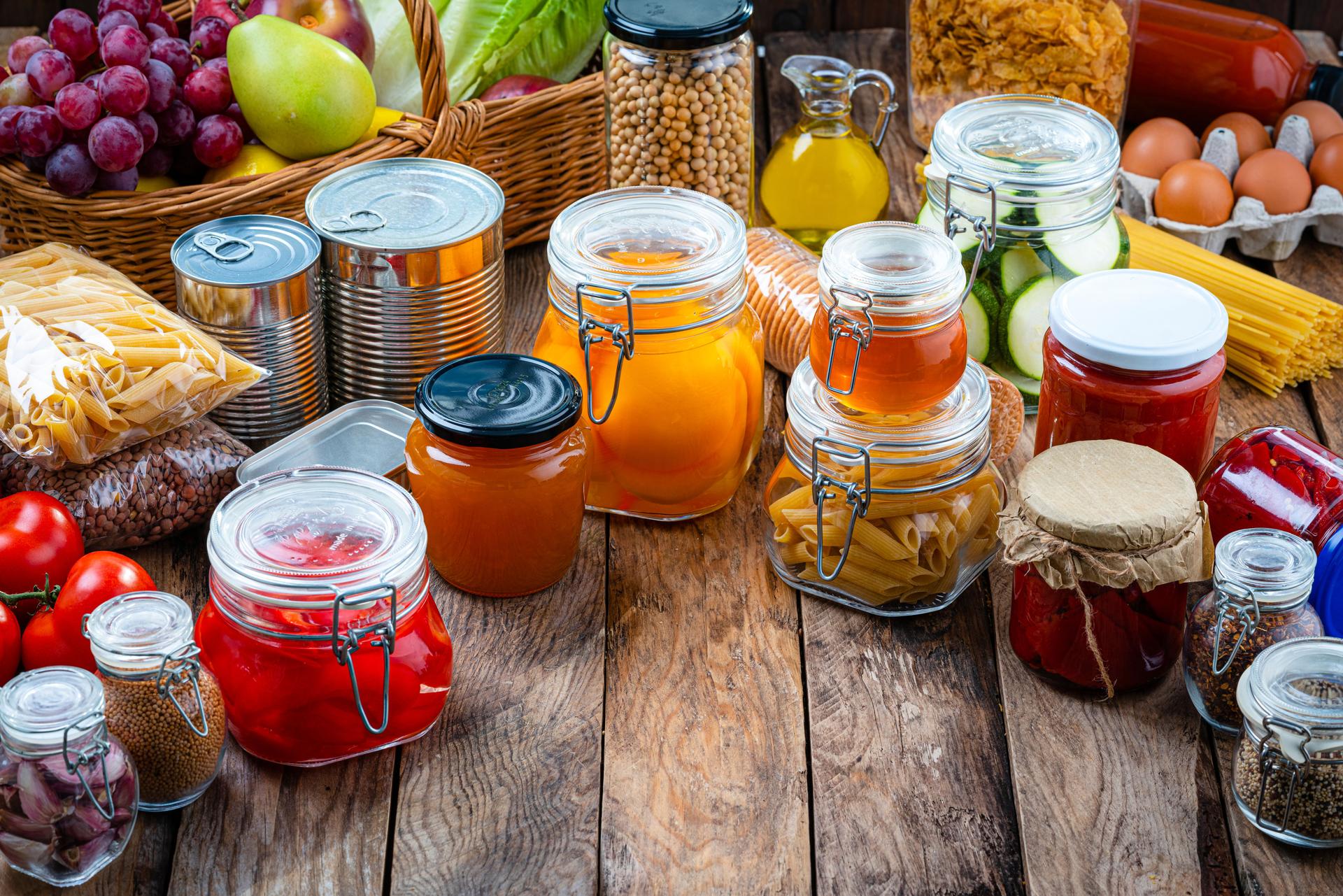 Preserved  food in glass jars and tin cans on rustic table