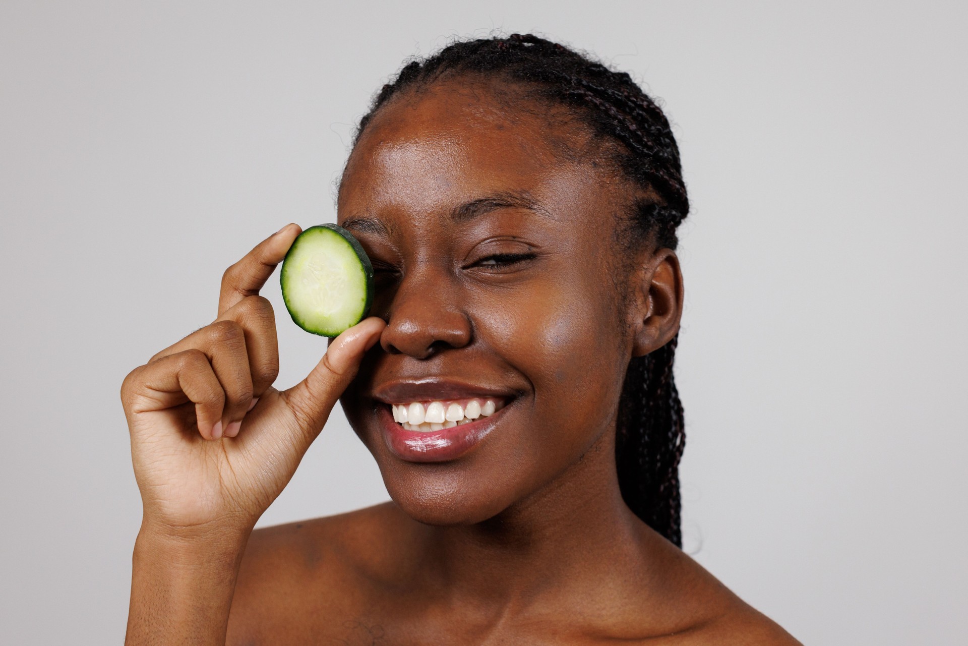 Black Woman Covering One Eye with Cucumber Slice